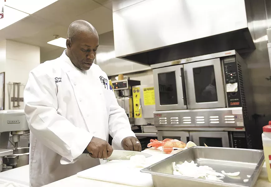 Derek Mobley preps onions for Union Gospel Mission's food service that feeds 5,000 every week. Mobley worked in the kitchen while getting clean. Now he's the boss. - YOUNG KWAK