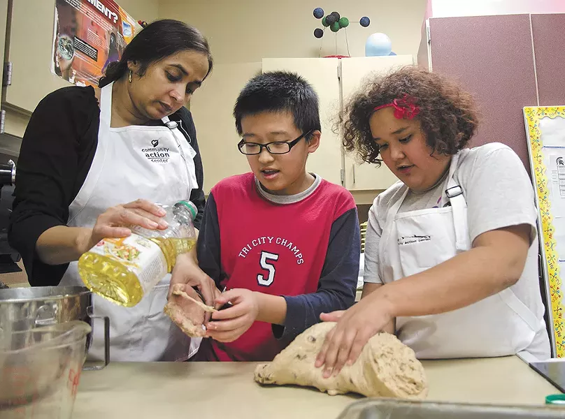 Tony and Napua learn breadmaking from volunteer Abtesam Khan at Pullman's Lincoln Middle School. - JACOB JONES