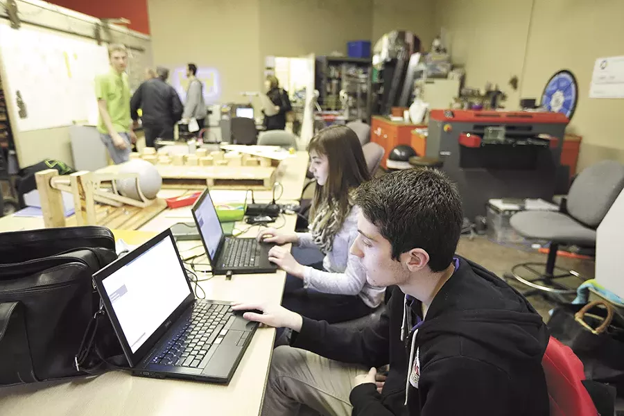Students Joe Broader, right, and Crista Falk work on programming for the team's robot. - YOUNG KWAK