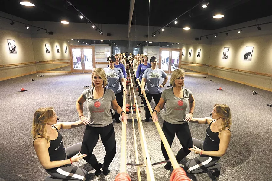 Pure Barre owner Katie Wood helps Leslie Lowe fine-tune a pose. - YOUNG KWAK