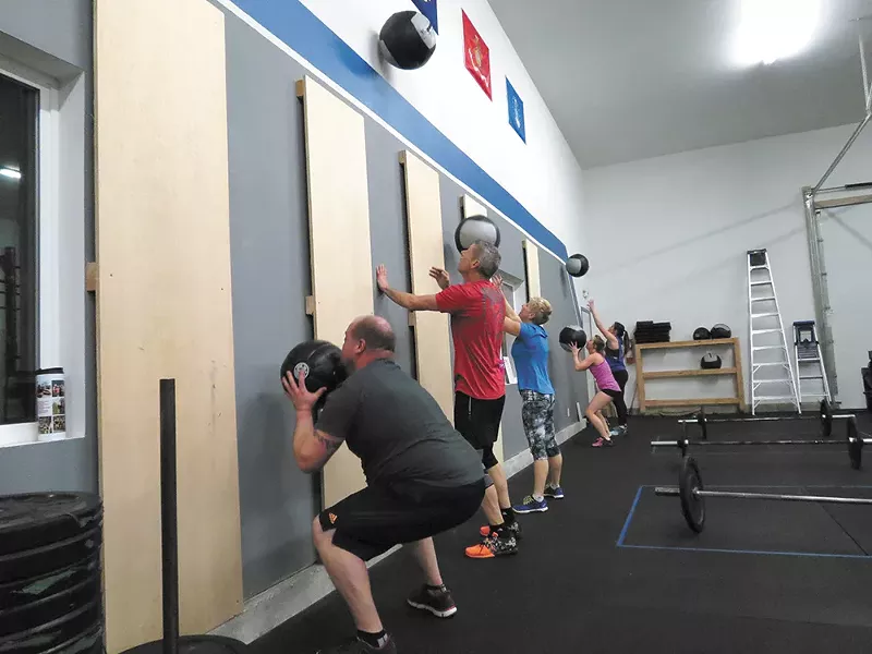 Strength training in small groups fosters bonding at CrossFit.
