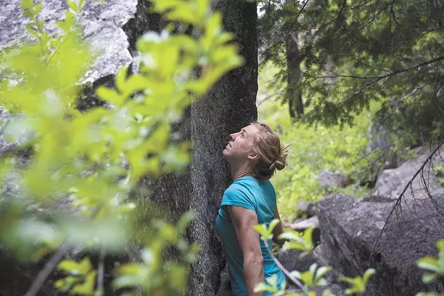 Carolyn Coffey makes her way up a boulder. - TARYN PHANEUF