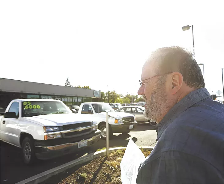 Chris Venne of Community Frameworks says this car lot will be replaced by apartments — but with a land bank, even more homes could have been built. - YOUNG KWAK