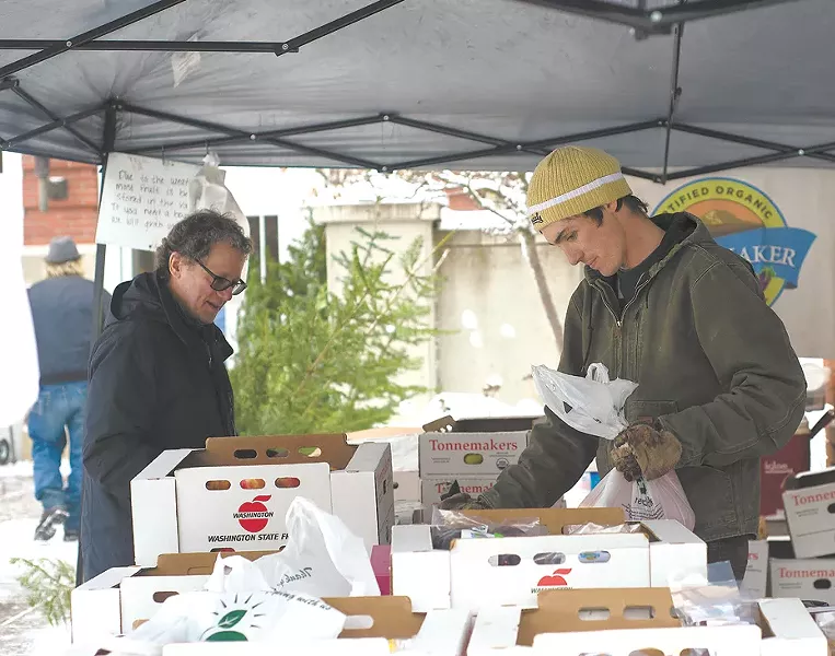 Luke Tonnemaker, right, sells apples and pears at his Moscow Winter Market booth. - TARYN PHANEUF