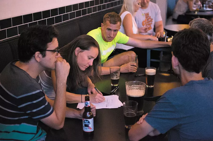 Teams discuss answers at Press's trivia night. - STUART DANFORD