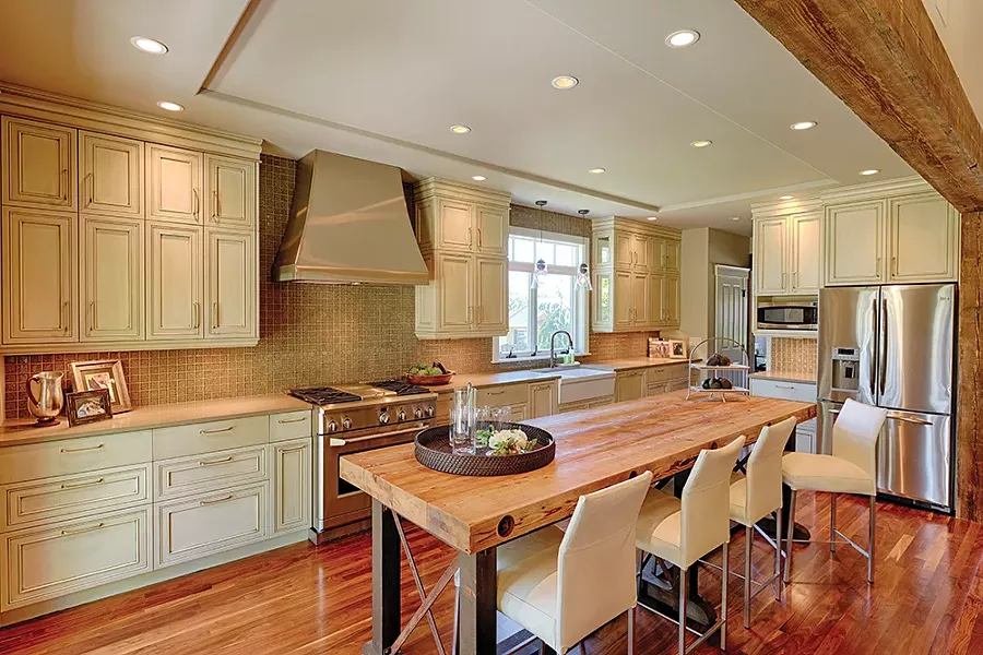 Designer Deanna Goguen created this kitchen in Spokane. "Islands made to look like architecturally salvaged pieces are really big." She notes sleek, uncluttered counters crafted from materials that are "less visually active" than granite appeal to clients. - ROCKET HORSE PHOTOGRAPHY, JON PECE PHOTO