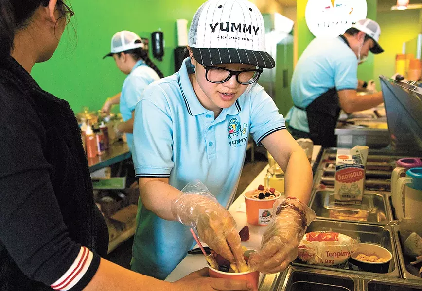 Becky Lin tops a cup of rolled ice cream. - LIBBY KAMROWSKI PHOTO