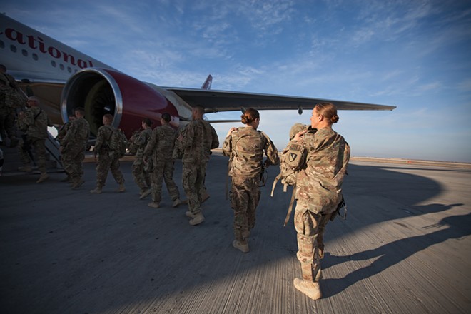US military service members returning from combat deployment in Afghanistan board an Omni Air International 777 for a flight home. - YOUNG KWAK