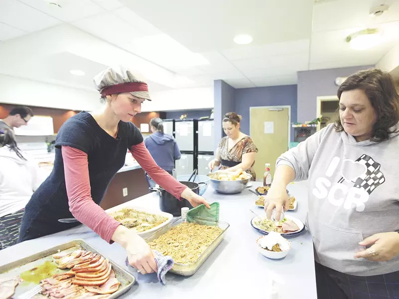 Volunteer Mandi Walters, left, serves green been casserole as St. Margaret’s Shelter resident Jenny Johnson tops pumpkin pie with whipped cream. - YOUNG KWAK