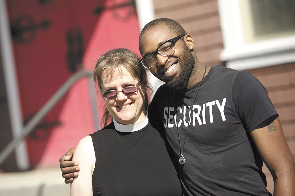 Volunteer Tasheem Gresham, left, and Rev. Kris Christensen in front of the Holy Trinity Chapel. Built in 1895, it’s the oldest church in the city. - YOUNG KWAK