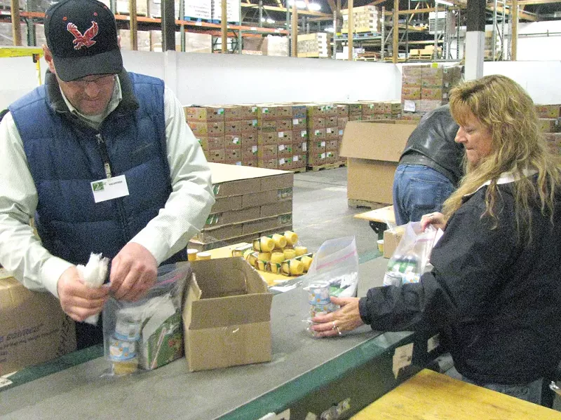 Volunteers pack the 468 weekend food packs that the Second Harvest Food Bank distributes every week.