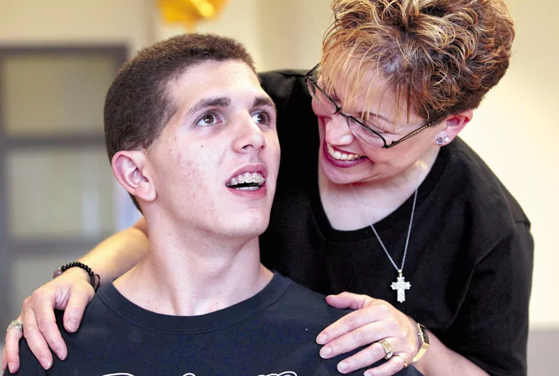 Zach Lystedt with his mom, Mercedes, last June, just before he graduated from high school — and nearly five years after his head injury. - ELAINE THOMPSON PHOTO/AP
