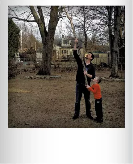 Chris Bourdeau helping his son Phin get a boomerang out of a tree in their backyard earlier this spring. Submitted by Kele Bourdeau, Burlington