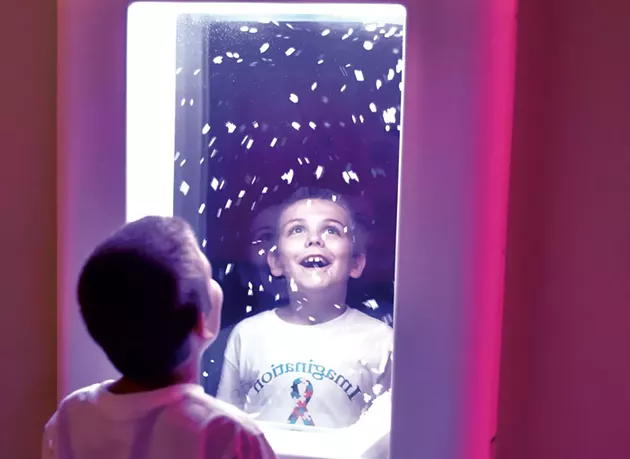 Ethan Slayton, 8, watching virtual snowflakes at an interactive wall panel - JEB WALLACE-BRODEUR