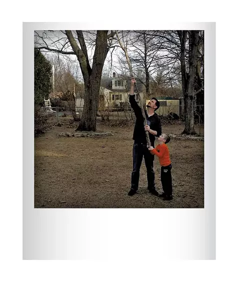 Chris Bourdeau helping his son Phin get a boomerang out of a tree in their backyard earlier this spring. Submitted by Kele Bourdeau, Burlington