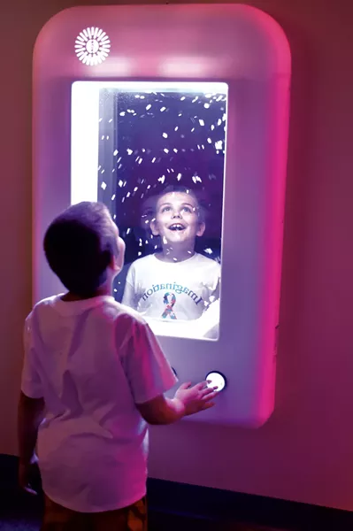 Ethan Slayton, 8, watching virtual snowflakes at an interactive wall panel - JEB WALLACE-BRODEUR