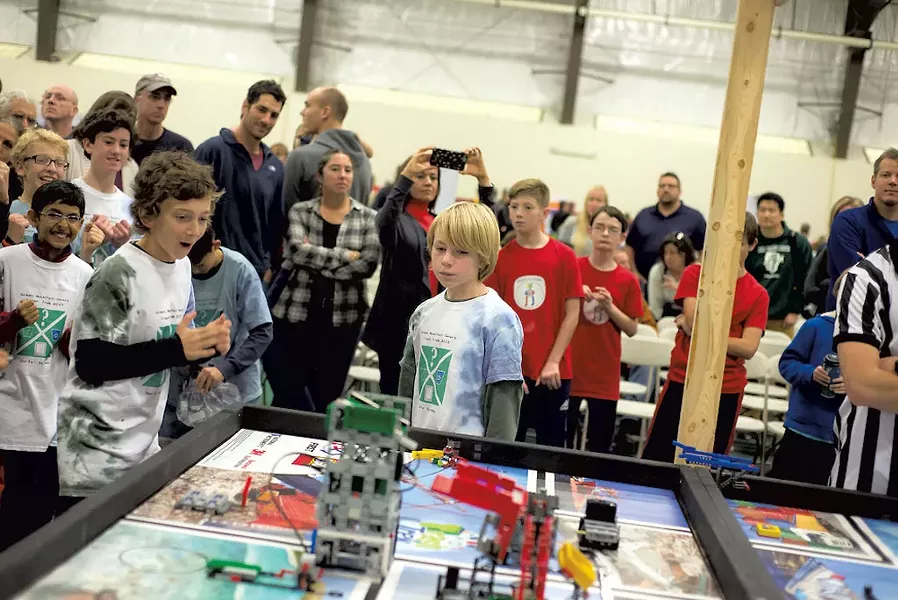 Members of the Green Mountain Gears watching as the irrobot navigates the gameboard at the FIRST LEGO League State Championships last November - COURTESY OF MARK COLLIER