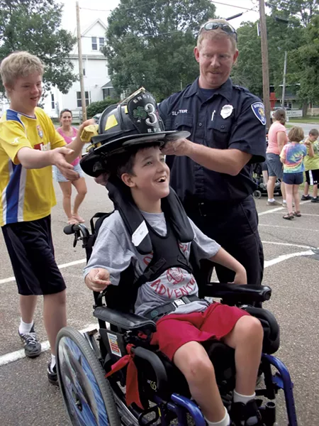 Ben tries on a firefighter’s hat - COURTESY OF DEBBIE LAMDEN