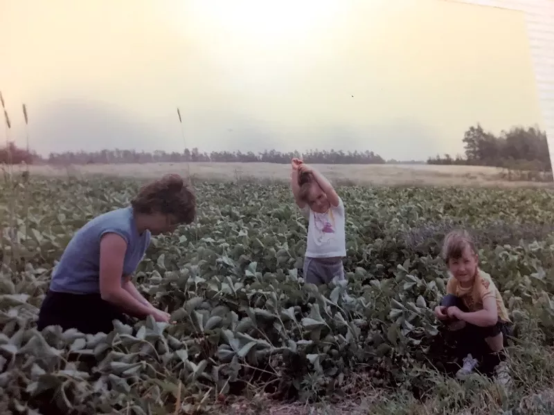 Amy (center) with her mom and sister in 1984, harvesting strawberries in Nova Scotia