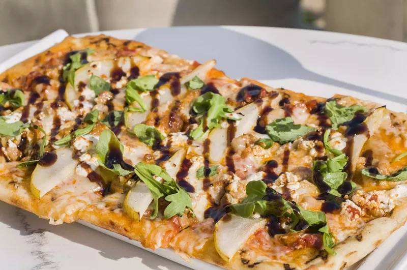 Flatbread with Italian sausage, marinara, garlic confit, goat cheese, fontina, roasted pears, arugula, balsamic. - TOM PERKINS