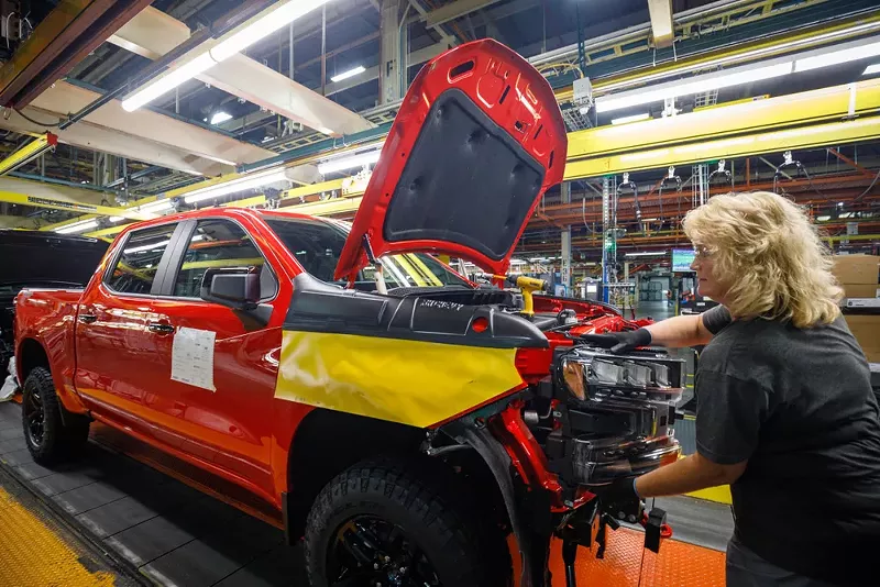 A worker installs a headlight assembly at GM's Chevrolet Silverado and GMC Sierra pickup truck plant. - JOHN GRESS MEDIA INC / SHUTTERSTOCK.COM