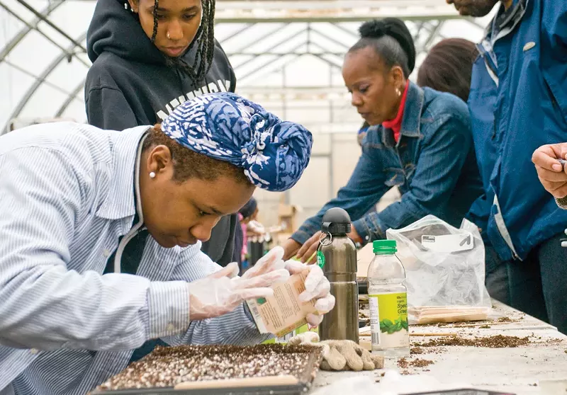 Students in Nerfer Ra Barber’s EAT program at Earthworks Farms work on picking out and planting seedlings in early April. - TOM PERKINS