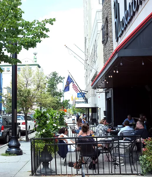 Lunchtime diners hang out on the outdoor patio at Blackstone's Pub& Grill in downtown Flint. - SCOTT ATKINSON