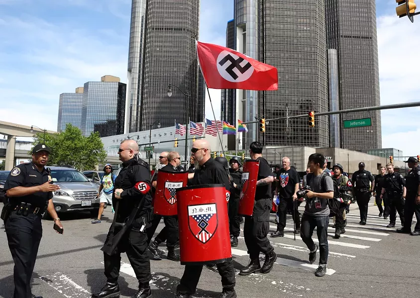 Emboldened by Trump? Members of the National Socialist Movement march with a Nazi swastika flag at Motor City Pride. - JIM URQUHART