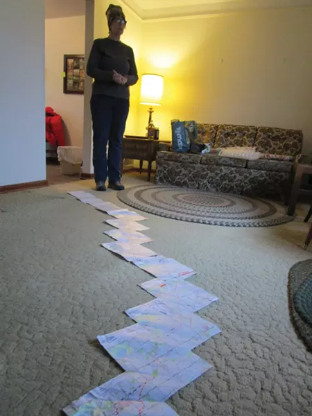 Kathy Schoen unspools a map of the proposed Nexus route through Michigan. - PHOTO BY MICHAEL JACKMAN