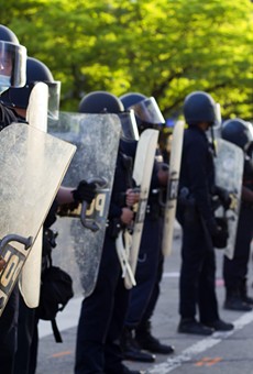 Detroit police clad in riot gear form a barricade outside Public Safety Headquarters.