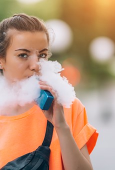 A young woman vaping nicotine.