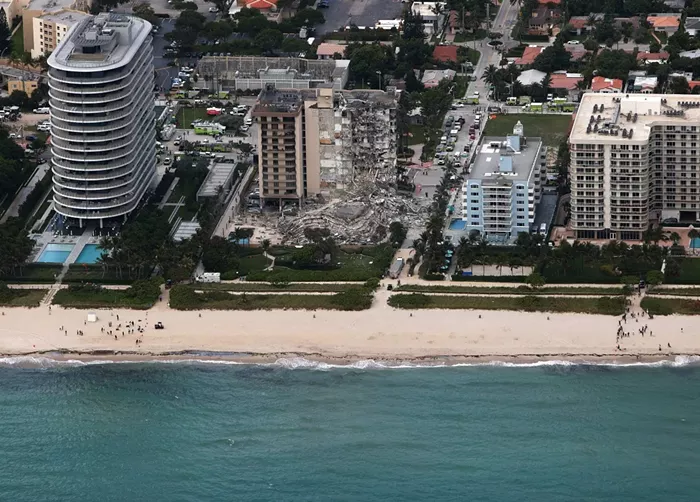 Miami architect Kobi Karp was initially involved in the plans for the 8701 Collins Ave. highrise (far left) just to the south of Champlain Towers South. - PHOTO BY JOE RAEDLE/GETTY