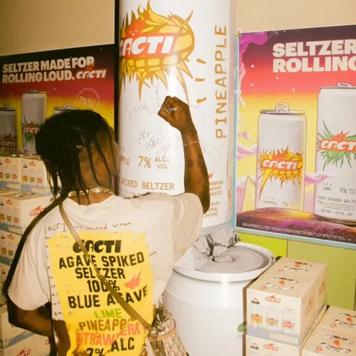 Travis Scott signs an oversized Cacti can at his stop in downtown Miami. - PHOTO BY WEBER SHANDWICK FOR CACTI