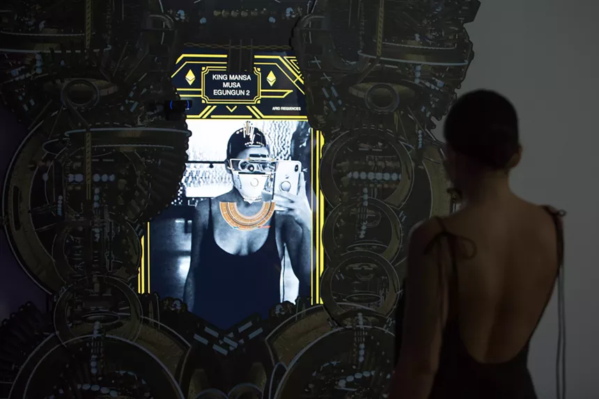 Artechouse's current exhibit, "ASE: Afro Frequencies," allows guests to virtually try on reimagined designs of African masks dating as far back as the 12th Century like an Instagram filter. - PHOTO BY MONICA MCGIVERN