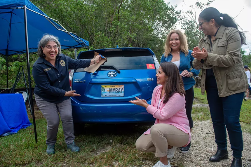Community members and local officials, including Miami-Dade County Mayor Daniella Levine Cava (far left), unveil the winning design for the Protect Biscayne Bay plate. - COURTESY OF MIAMI-DADE COUNTY