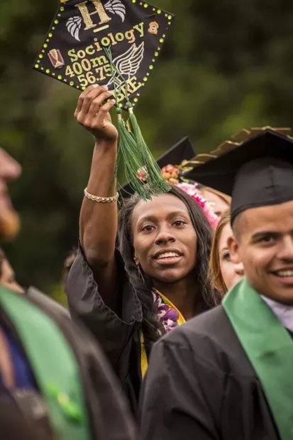 Brejeque Collins, sociology major and HSU student athlete in the womens 400-meter run, held her inscribed hat aloft as she exited the Redwood Bowl field following commencement. - MARK LARSON