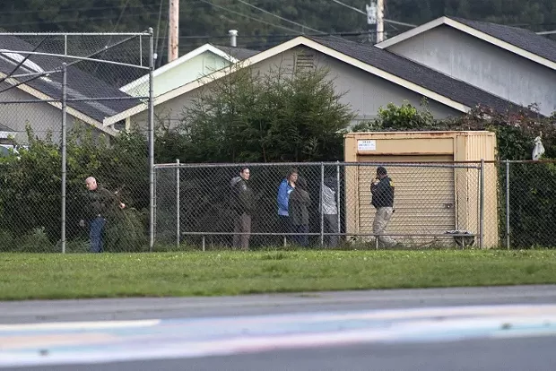 Officers search for a discarded firearm at Cutten Elementary School. - MARK MCKENNA