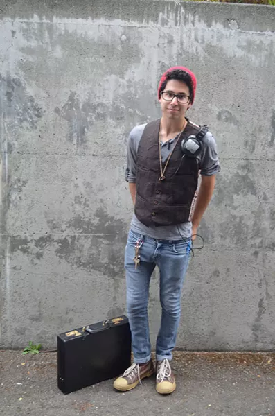 Jonathan Arevalo, a history student from Southern California, likes the forest landscape here. Not a lot of shopping for a student on a budget, but the briefcase, vest and headphones thing is working. - PHOTO BY SHARON RUCHTE
