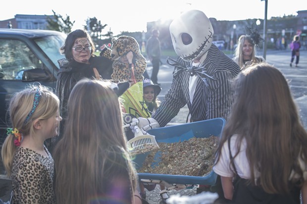 Kevi from Panache, passes out 'kitty litter cake' to trick-or-treaters on the plaza Friday. - ALEXANDER WOODARD
