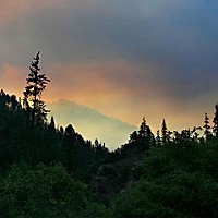 Smoke from the Jake and Portuguese fires hangs in the air over the Salmon River road at dusk. Photo by Yulia Weeks