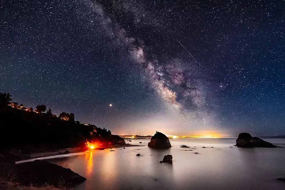 Looking south from Tepona Point during the Perseid meteor shower, August of 2018. The bonfire of a group of Perseid meteor gazers blazed on the curve of Houda Point Beach, a beautifully warm counterpoint to the stars and planets above. - PHOTO B Y DAVID WILSON