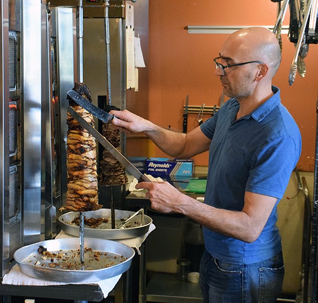 Salhi carving shawarma during lunch. - PHOTO BY THAD GREENSON