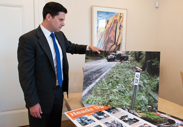 Attorney Ben Mainzer with a photograph of the crash scene. - MARK MCKENNA