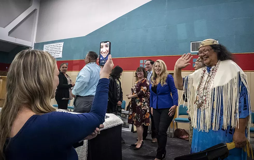 Wiyot tribal elder Cheryl Seidner (right) waves hello to Eureka City Councilmember Natalie Arroyo, who was watching the ceremony via Facetime (with a little help from Eureka Executive Assistant Christine Tyson) while deployed on active duty orders with the U.S. Coast Guard in Georgia. - BY MARK LARSON