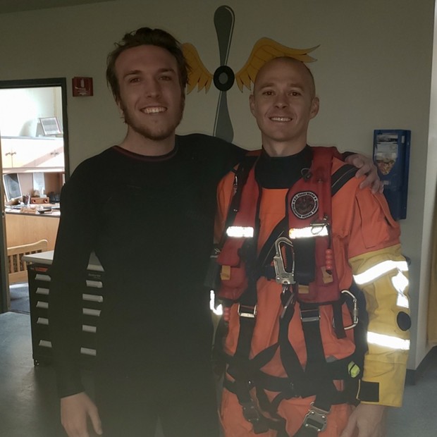 Petty Officer 2nd Class Michael Hernon, a Coast Guard Sector Humboldt Bay rescue swimmer, stands with Kris Nagel, a distressed surfer who was rescued by the Coast Guard when he was reportedly swept toward rocks near Moonstone Beach while he was surfing, Dec. 15, 2019. A Sector Humboldt Bay MH-65 Dolphin helicopter crew was dispatched to the scene, hoisted Nagel into the helicopter and took him to California Redwood Coast - Humboldt County Airport where he was transferred to emergency medical services personnel. - COURTESY OF THE U.S. COAST GUARD SECTOR HUMBOLDT BAY