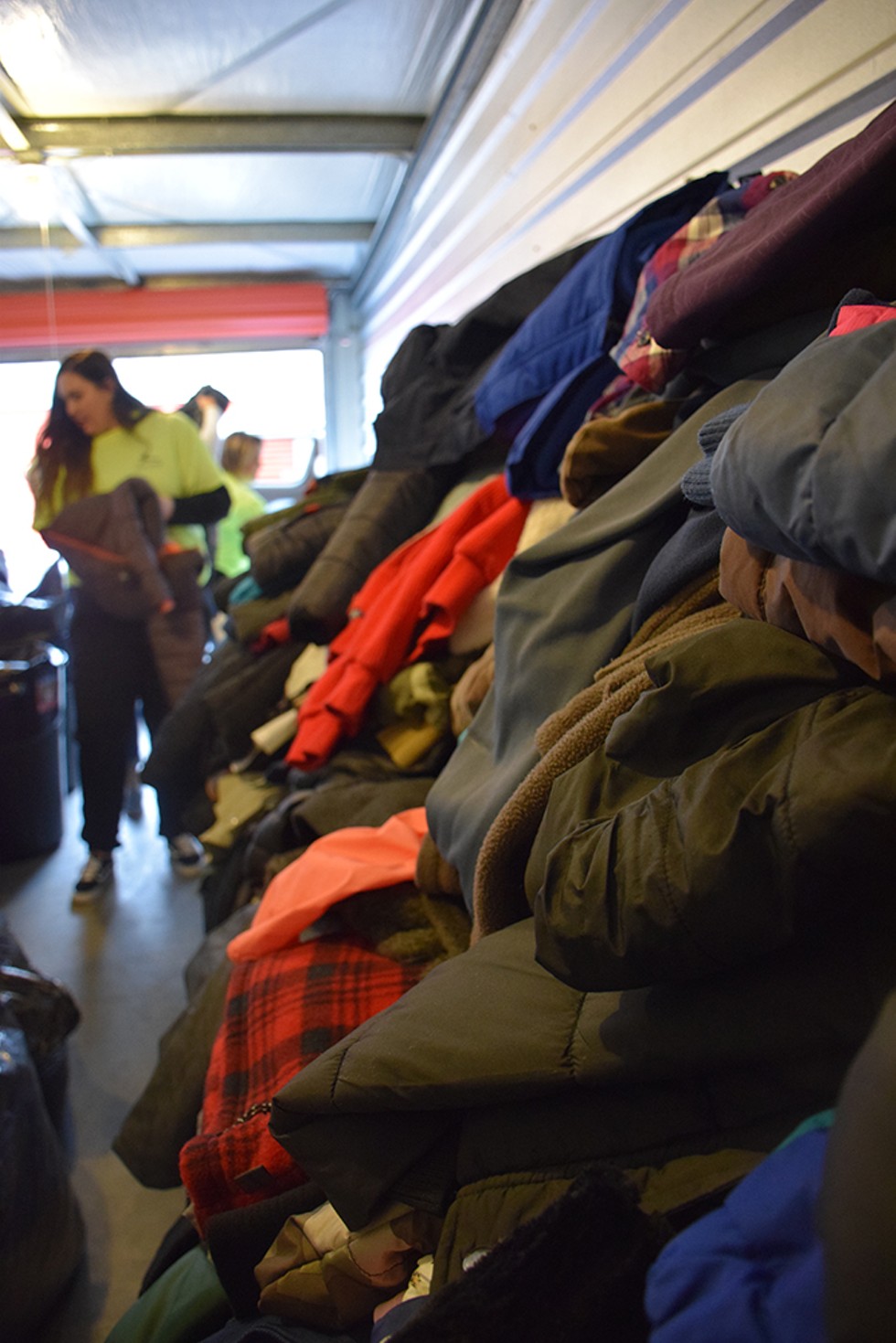 Volunteers sort hundreds of donated coats. - PHOTO BY THADEUS GREENSON