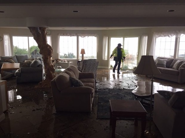 A member of Shelter Cove Fire inspects the damage including water on the floor of this custom-built home. - CHERYL ANTONY OF SHELTER COVE FIRE