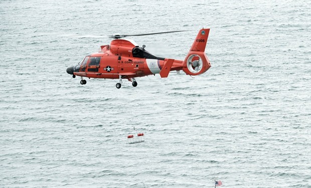 An MH-65 Dolphin helicopter crew from Coast Guard Air Station Humboldt Bay lowers a rescue basket to a 47-foot Motor Lifeboat crew during training in Eureka, Calif., March 7, 2018. Coast Guard helicopter crews routinely conduct training with small boat crews to maintain their qualifications and so that in the event of a medevac request from a boat or ship, the crews are proficient in their lifesaving techniques. - COAST GUARD PHOTO BY CHIEF PETTY OFFICER BRANDYN HILL