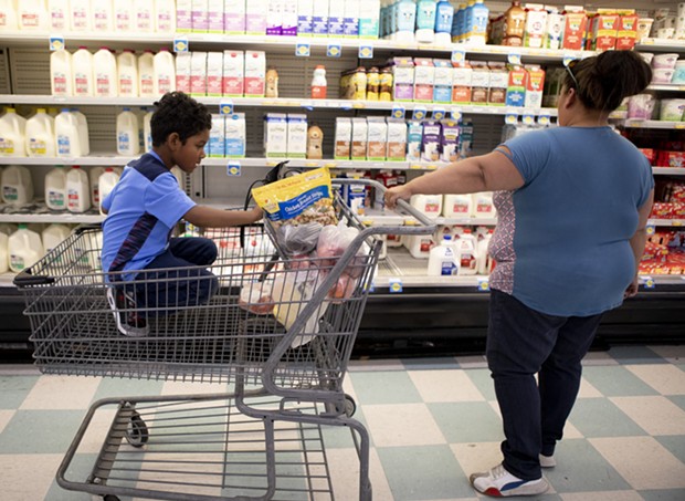 California is sending pandemic food cards to qualifying students. In this file photo, Antionette Martinez and her son Caden, 5, who receive CalFresh, do their weekly grocery shop at FoodMaxx on July 26, 2019. - ANNE WERNIKOFF FOR CALMATTERS