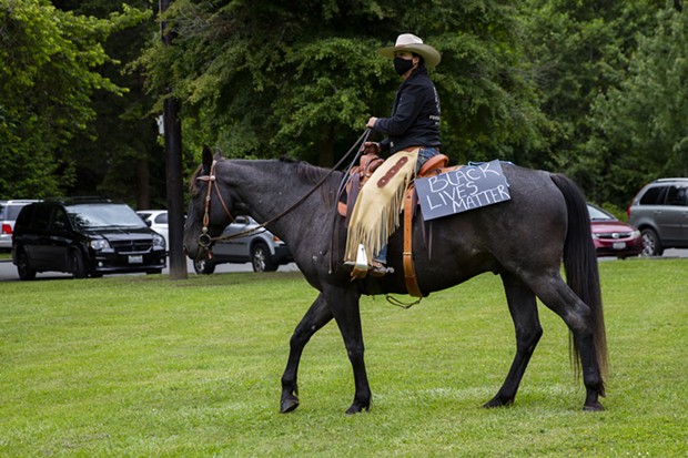 Wild Souls Ranch Executive Director Savanah McCarthy rides with a Black Lives Matter sign on her horse at Rohner Park in Fortuna while demonstrators gather to protest police brutality and racism on June 5. - THOMAS LAL